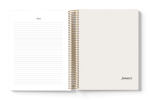 Open spiral-bound planner with lined pages and 'January' text on a white background